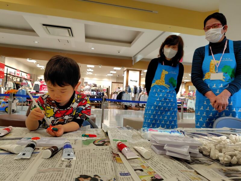 マグネットに色を塗っている子供を見守る様子