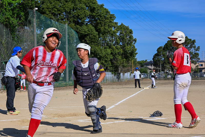 笑顔でホームベースを踏む子供の写真