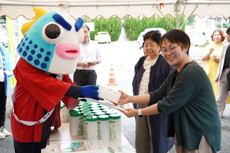 配布されたオリジナルボトルを受け取る様子