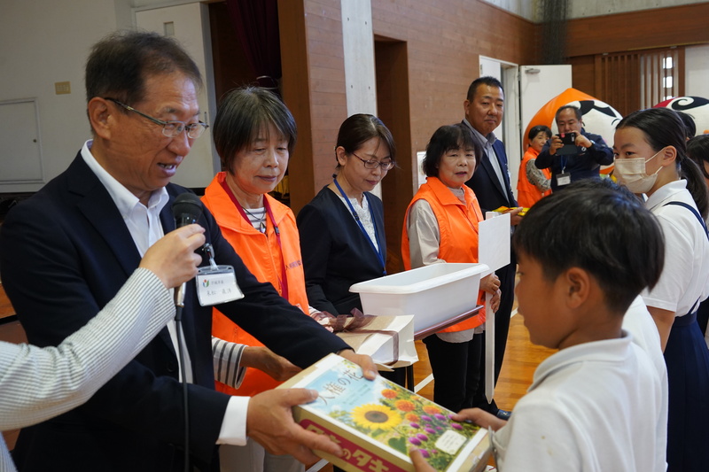 市長から児童へ種が手渡される様子