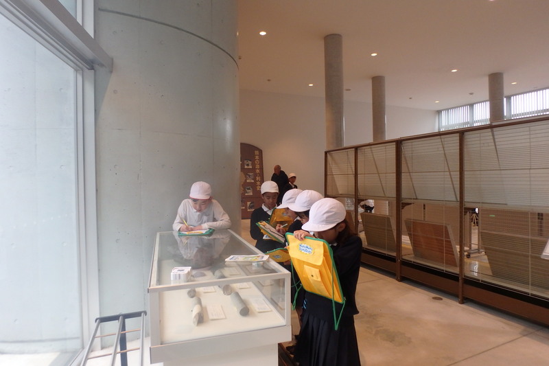 資料館の展示物を見ながらメモをしている様子