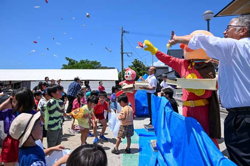 まかれたお菓子を拾う子供達